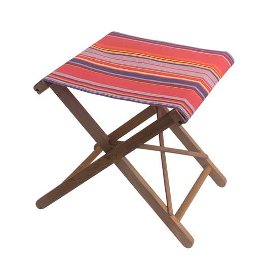 Teak folding stool featuring colourful multi-striped cotton fabric with vibrant pinks, lavender, purple, yellow, and orange. Petit Sixtine is a fabric made by Les Toiles do Soleil. Placed on a white background