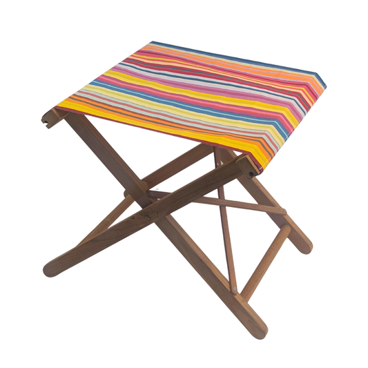 A teak folding stool with a colourful striped Sunbrella Jour de Fete fabric top  shown on a plain white background.