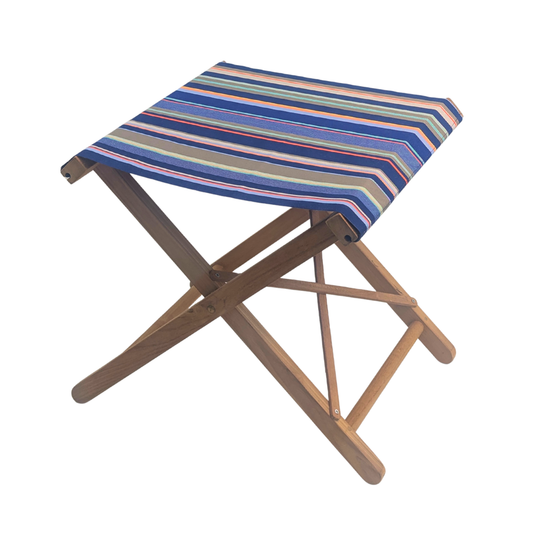 A folding teak wooden stool with a striped fabric seat cushion in shades of blue, red, beige, and green, shown on a plain white background.