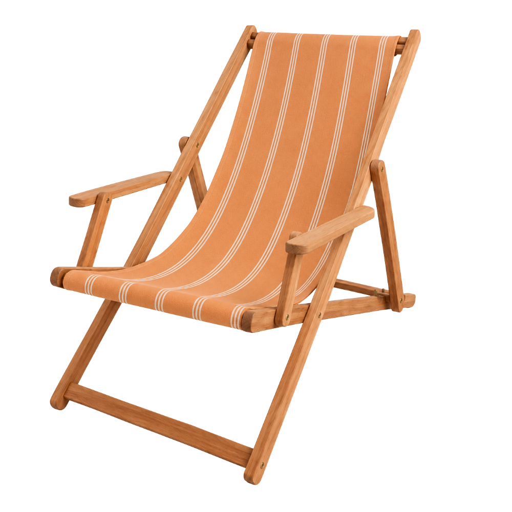 Teak wooden deckchair with arms, featuring a peach and cream striped sling by Sunbrella. On a plain background