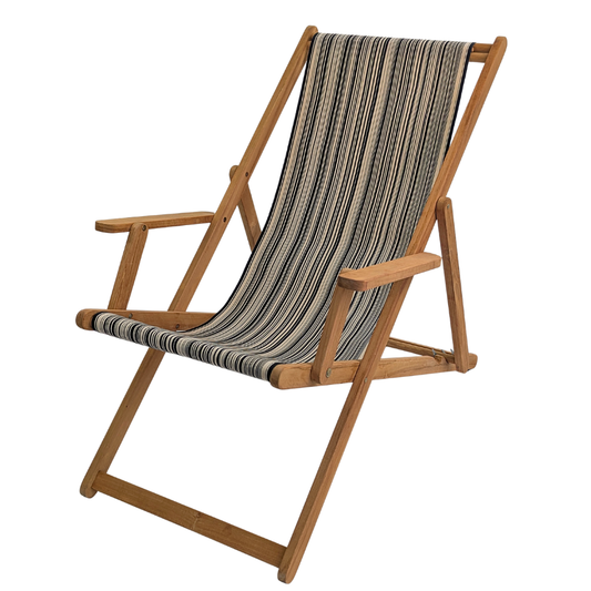 A teak deckchair with arms featuring the Les Toiles du Soleil cotton fabric Tom Black. Showcasing sharp black and white stripes for a bold, architectural aesthetic. On a white background