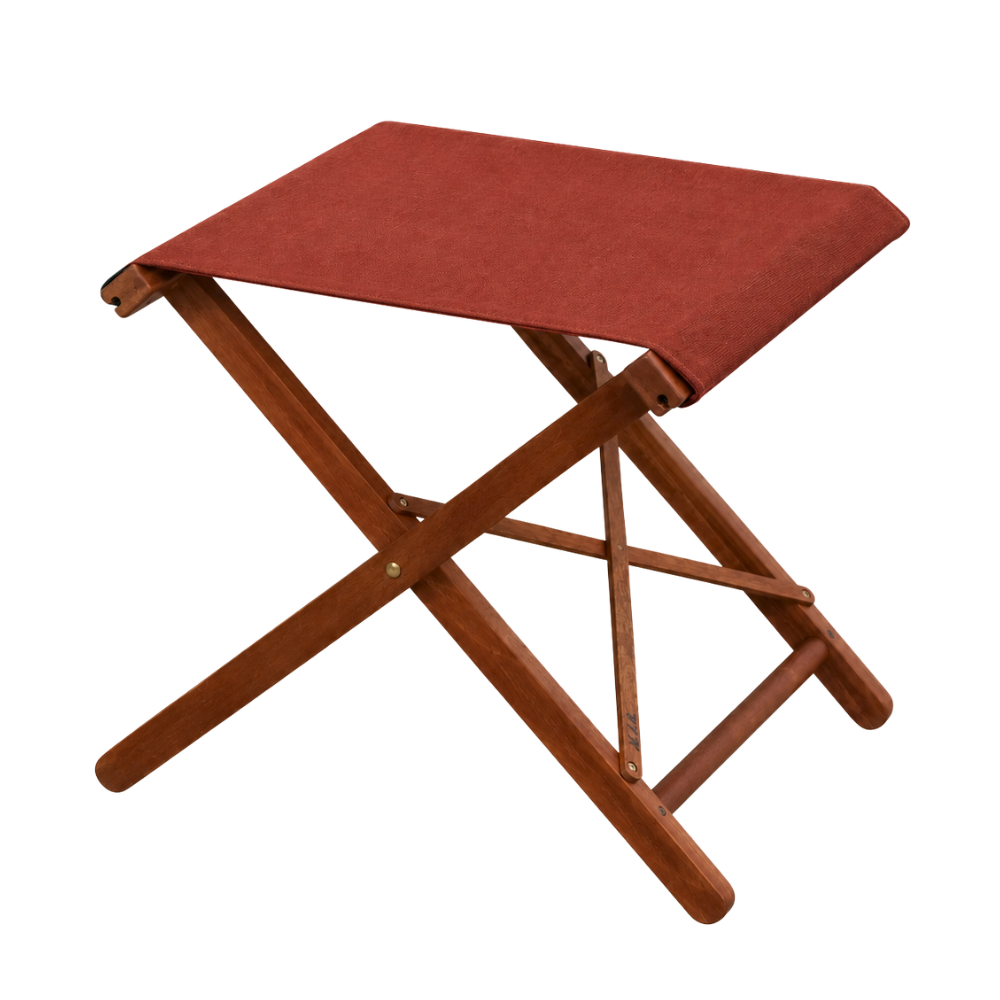 Hardwood folding stool with a Terracotta coloured fabric sling by Sunbrella. One a plain background