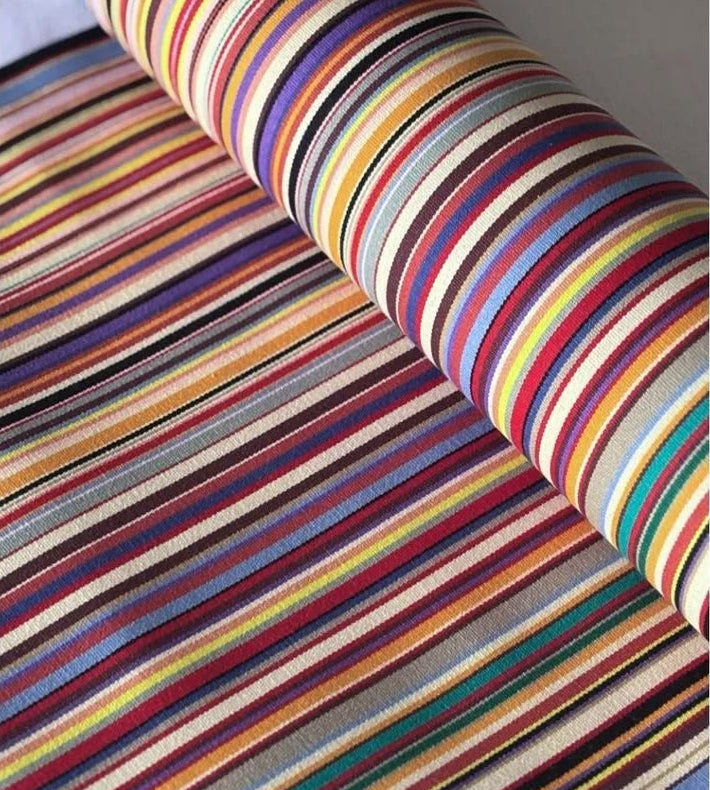 Roll of Les Toiles du Soleil roll of Tom Multi Outdoor Sunbrella Fabric, featuring multi coloured striped fabric with a close-up view.