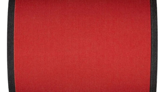 
Cotton fabric roll in a plain warm terracotta red with bold black selvedge edges.
