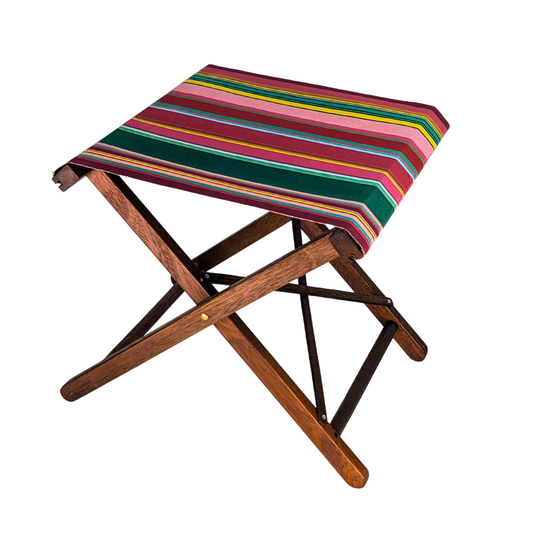Hardwood folding stool featuring cotton fabric with stripes of red, purplish crimson, candy pink, green, blue and golden yellow, inspired by the colours of the Catalan town of Toulouges and its famous onion.