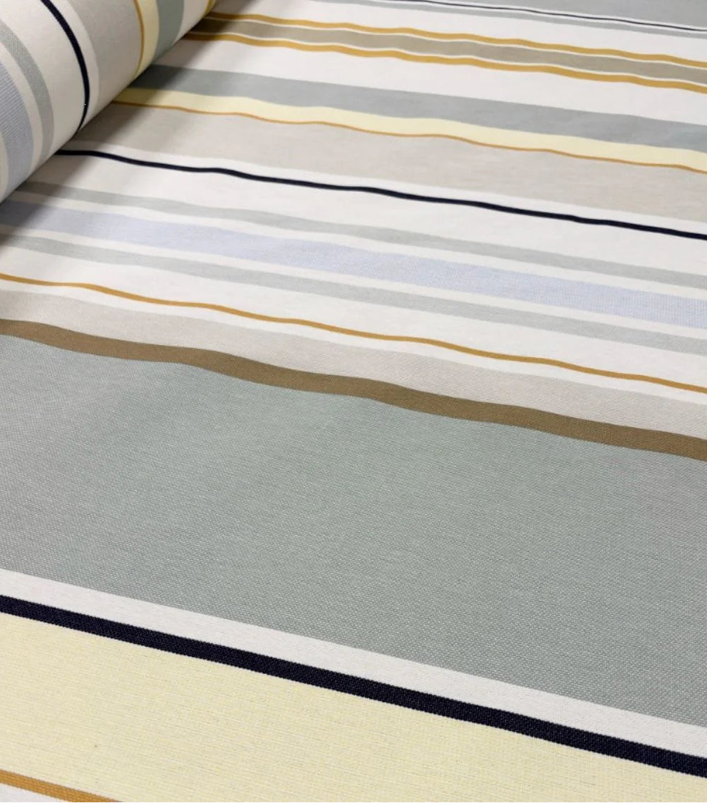 CLose up of Trianon fabric, which reflects a delicate palette of soft greys, pale yellow, and sky blue, gently illuminated by touches of gold. A 100% cotton Les Toiles du Soleil fabric roll