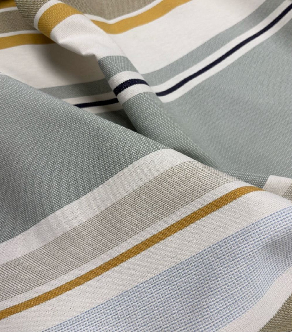 Close up of Trianon fabric which reflects a delicate palette of soft greys, pale yellow, and sky blue, gently illuminated by touches of gold. A 100% cotton Les Toiles du Soleil fabric.