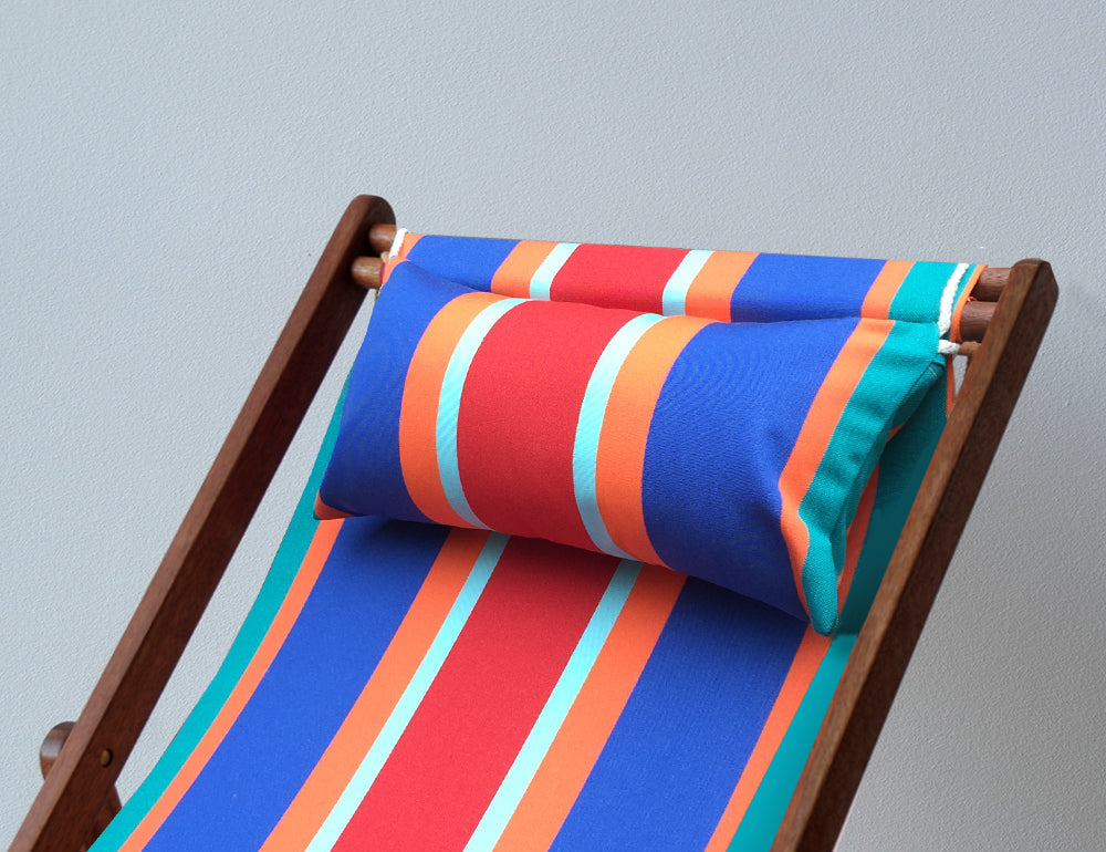 A striped head cushion placed on a wooden deckchair, featuring vibrant colors.